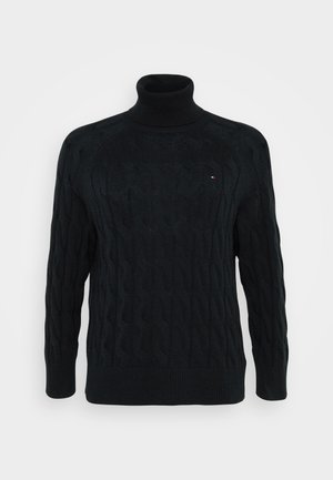 Svart turtle neck genser laget av teksturert strikket materiale, med et kabelmønster, ribbestrikkede mansjetter og en liten logo på brystet.