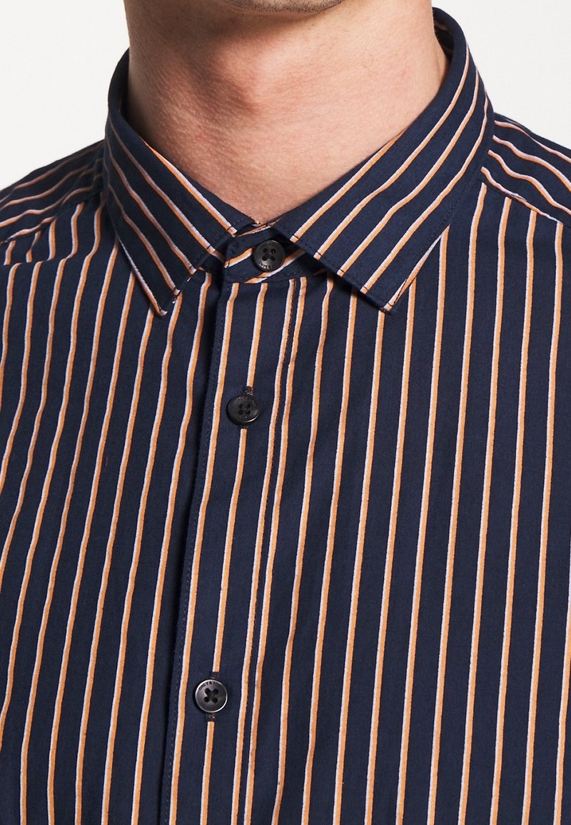 Camicia a righe blu navy e arancioni con bottoni, dotata di colletto alla francese e bottoni neri. Il tessuto ha una texture liscia.