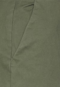 Dark green fabric with a subtle texture and diagonal seam detail. The material appears durable and has a slight sheen.