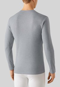 Maglietta a maniche lunghe di un grigio chiaro, realizzata in materiale morbido, con scollatura rotonda e design senza cuciture ai polsini e all'orlo.