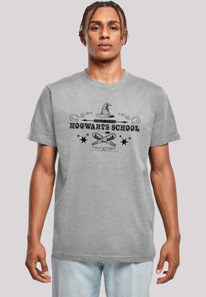 Gray cotton t-shirt featuring a Hogwarts School graphic, including a sorting hat, "First Year," and crossed wands, with decorative accents.