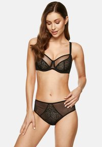 Czarny zestaw biustonosza koronkowego i majtek z przezroczystymi panelami oraz kwiatowymi wzorami, zaprojektowany z fiszbinami i regulowanymi ramiączkami.