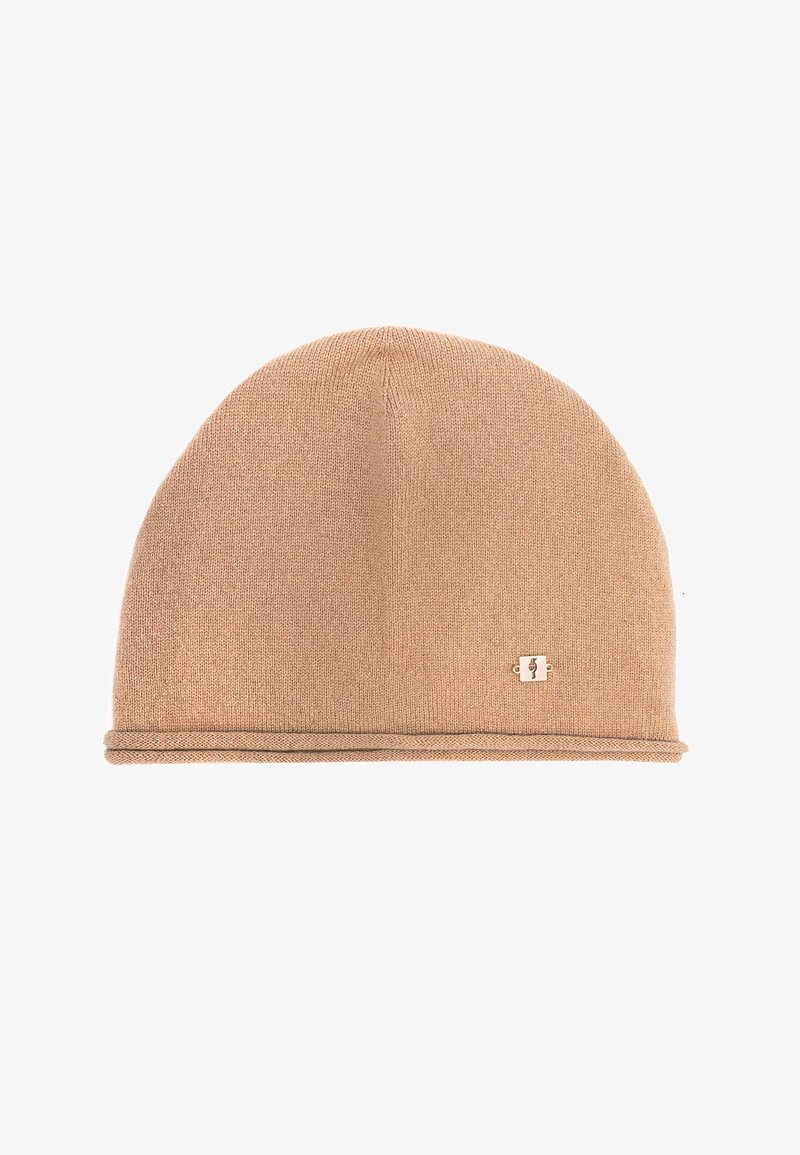 Beżowa, dziana czapka beanie o gładkiej fakturze, zaokrąglonym kształcie i cienkim pasku. Posiada małe, złote logo na białym tle.