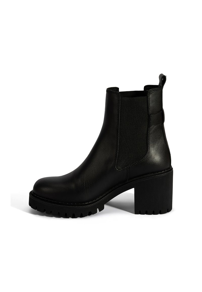 Bottine en cuir noir avec des panneaux latéraux élastiques, un talon bloc épais et une semelle en caoutchouc texturé pour une meilleure traction. Design minimaliste.