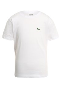 Vit bomull t-shirt med rund halsringning och korta ärmar. Har en liten grön broderad krokodil-logotyp på vänster bröst.