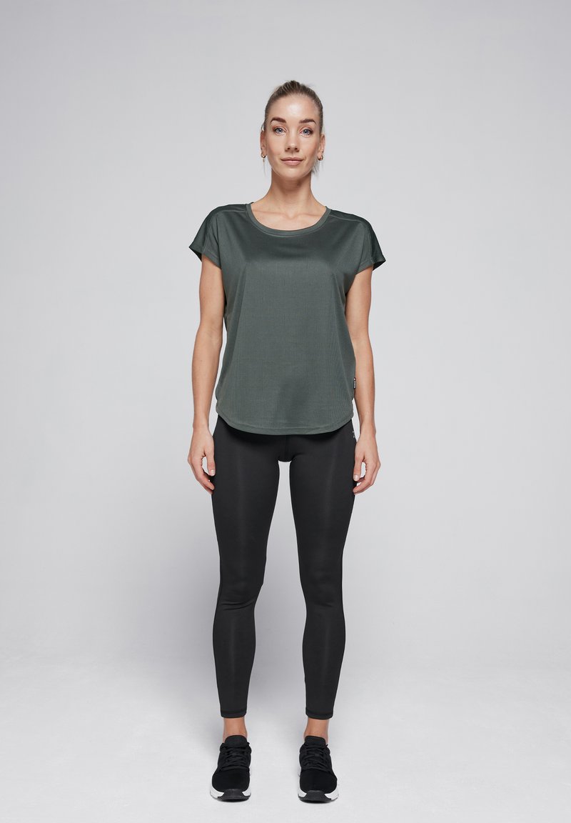 Dark green athletic t-shirt with short sleeves, smooth texture, round neckline; paired with black fitted leggings and dark sneakers.