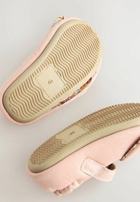 Chaussures en tissu rose doux avec des accents à motifs, dotées de semelles en caoutchouc texturé et de bandes velcro ajustables pour un maintien sûr.
