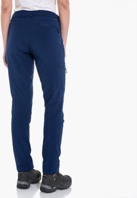 Dunkelblaue Outdoor-Hosen mit schlanker Passform, elastischem Bund und einer seitlichen Reißverschlusstasche. Texturiert Stoff und verstärkte Nähte sichtbar.