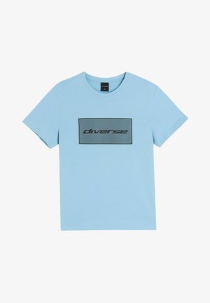 Jasnoniebieski T-shirt z krótkim rękawem, z czarnym prostokątnym nadrukiem i ukośnymi liniami, z napisem „diversee” w stylizowanym tekście na piersi.