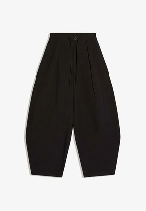 Czarne spodnie o szerokich nogawkach z wysokim stanem, z przodem na guziki i wiązaniem na ściągacz, z wąskim wykończeniem przy kostkach.