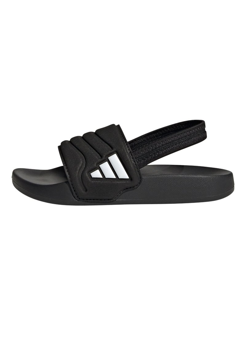 Černá pantofle na kluzáku s gumovou podrážkou, polstrovaným páskem s texturovaným vzorem a třemi bílými pruhy na straně. Lehká a nastavitelná.