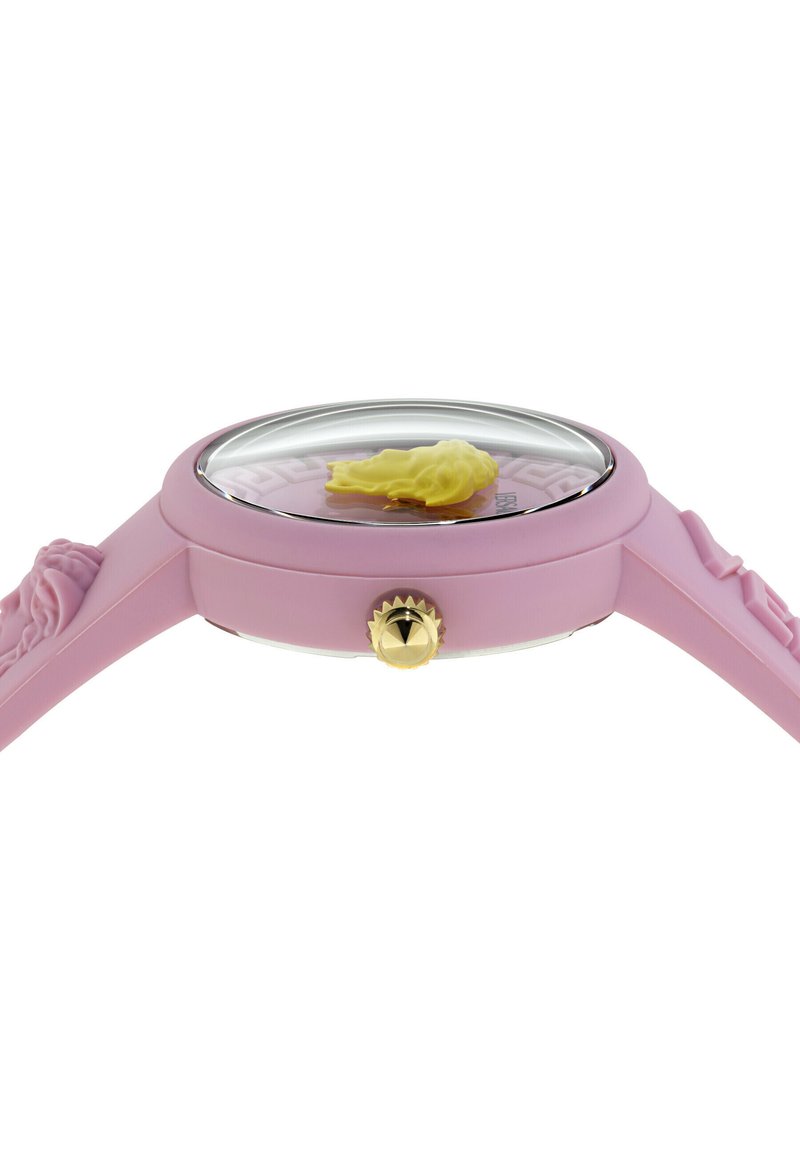 Rosa Armbanduhr mit einem erhobenen, gelben Löwenkopf auf dem Zifferblatt, pinkem Armband mit geprägten Löwenköpfen und einer goldfarbenen Krone.