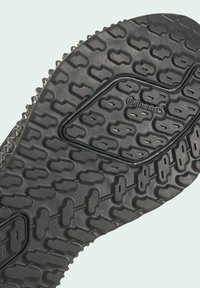 Semelle de chaussure en caoutchouc noir avec motif de bande de roulement texturée et logo "Continental" embossé près du centre.