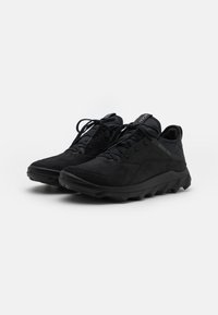 Scarpe sportive nere in suede con finitura texturizzata, dotate di una suola in gomma spessa, lacci e occhielli rinforzati.