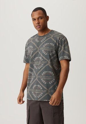 Koszulka z krótkim rękawem, okrągłym dekoltem w kolorze szarym, z geometrycznym wzorem przedstawiającym oliwne gałęzie oraz okrągłe akcenty w stonowanych kolorach.