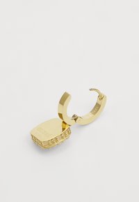 Gold-plated steel earring featuring a rectangular charm with a textured edge and engraved text, attached with a rounded hoop closure.