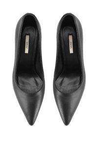 Une paire de chaussures à talons hauts noires en cuir à bout pointu vues de dessus sur un fond blanc.