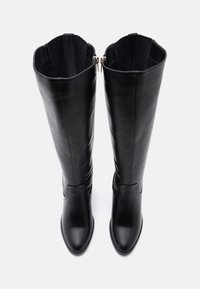Black leather knee-high boots with a pointed toe, smooth texture, and zip closure at the back, featuring a fitted shaft and minimal stitching.