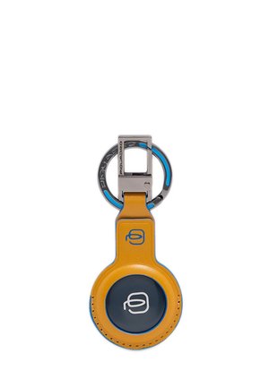 Yellow leather keychain with a round dark center featuring a white logo and a metal keyring with blue accents.