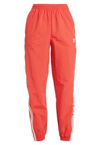 Röda, lätta joggerbyxor med elastisk midja; har vita ränder på sidorna och en liten logga framtill på vänster sida.