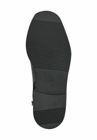 Black shoe bottom showing rubber material with ridged texture and circular branding. Size 37 marked; smooth toe and heel for even wear.