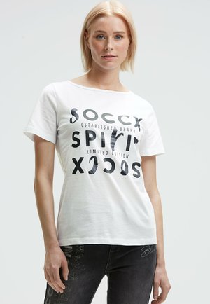 White short-sleeve t-shirt featuring black printed text with varying fonts and letters. Soft cotton material with a relaxed fit.