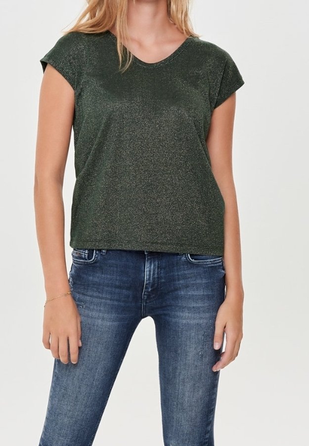 Femme portant un haut vert foncé à manches courtes et un jean bleu, debout les bras détendus le long du corps.