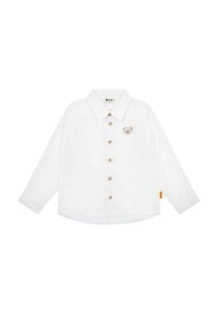 Camicia bianca a maniche lunghe con colletto a punta, bottoni dorati e motivo di un orso sul lato sinistro del petto. Presenta un orlo arrotondato con un'etichetta laterale.