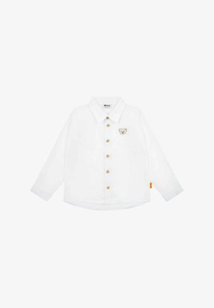 Chemise blanche à manches longues avec un col pointu, des boutons dorés et un motif d'ours sur la poitrine gauche. Caractérisée par un ourlet arrondi avec une étiquette sur le côté.