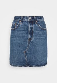 Blå denim minikjol med framfickor, bältesöglor, knäppning och kontrasterande orange sömmar mot en vit bakgrund.