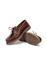 Chaussures de bateau en cuir marron avec une fermeture à lacets, un intérieur rembourré et une semelle en caoutchouc durable dotée d'un motif de semelle texturée.