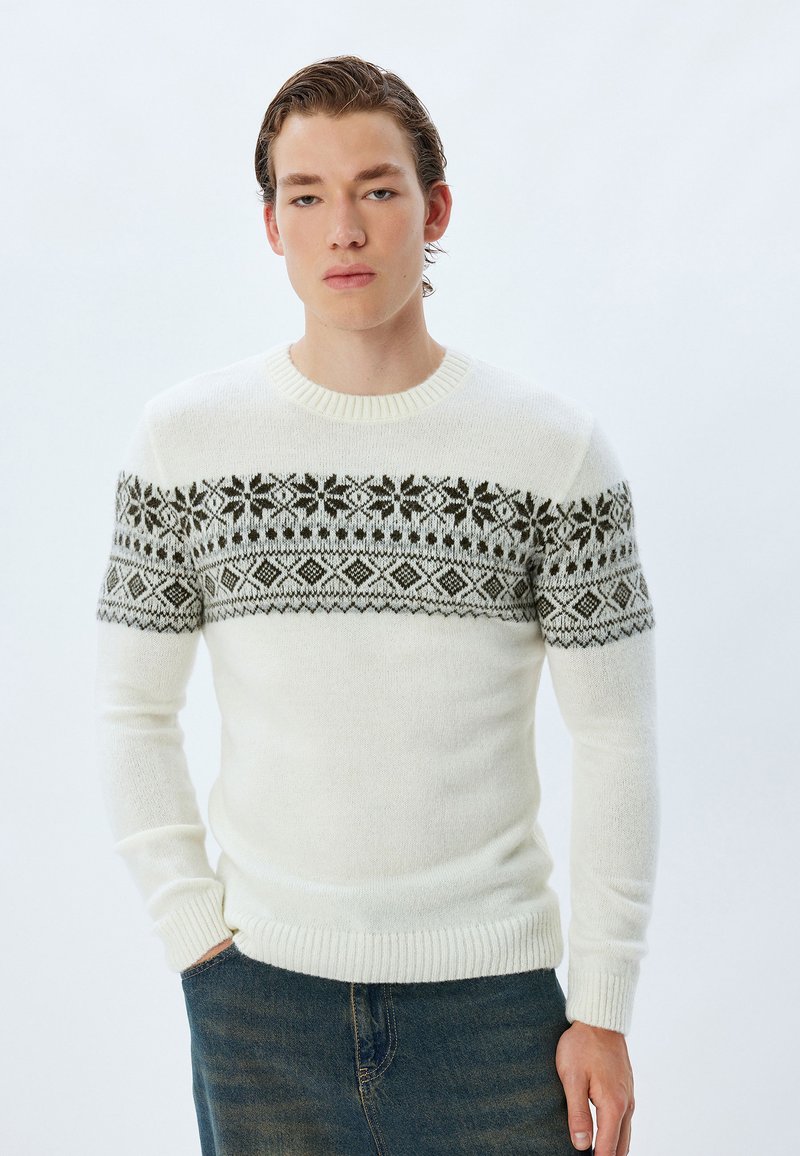 Strickpullover in Creme mit einer gemusterten, dunkelgrauen Passe, die geometrische Designs zeigt. Verfügt über einen Rundhalsausschnitt sowie gerippte Bündchen und Saum.
