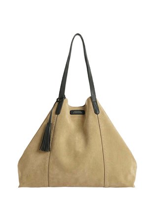 Sac fourre-tout en daim beige avec de longues poignées en cuir noir et un pompon, arborant une petite étiquette noire à l'avant.