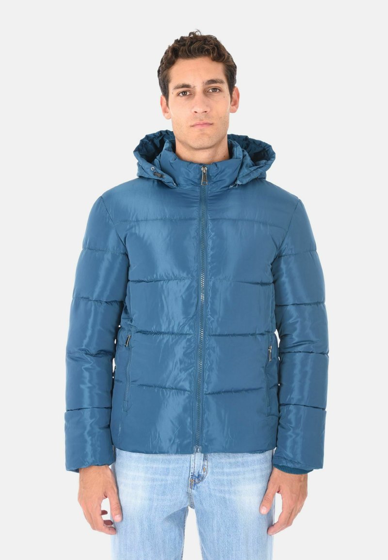 Giacca imbottita blu tipo puffer con cappuccio, chiusura a zip e tasche laterali. Presenta una texture lucida e dettagli di cuciture orizzontali.