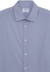 Camicia slim-fit blu con stampa geometrica, dotata di colletto a punta, chiusura con bottoni e texture liscia. Il tessuto presenta un motivo fine in tutta la sua superficie.