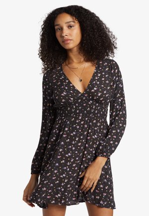 Vestido negro de manga larga, con escote en V y cintura fruncida. Presenta pequeños patrones florales en rosa y azul. Tela suave y ligera.