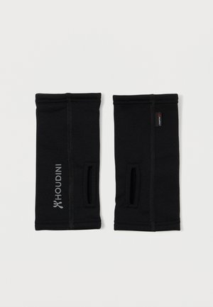 Pair of black wrist gaiters with thumb holes, visible seams, Houdini logo on one side, and Polartec fabric tag on the other.