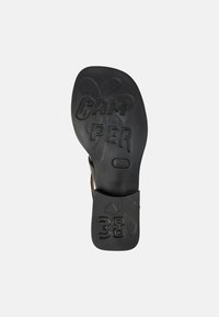 Suela de goma negra con el logo "CAMPER" en relieve y tamaño "38". Presenta una textura suave y forma redondeada, diseñada para la comodidad.