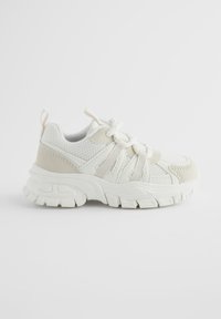 Pantof sport alb cu detalii din plasă și piele întoarsă, cu talpă groasă și texturată și șireturi elastice. Culoare accent în bej deschis.