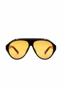 Occhiali da sole con montatura in plastica nera, forma ottagonale e lenti di colore arancione. Presentano delle aste spesse con una finitura liscia.
