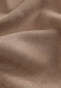 Tissu doux, marron, à effet daim avec des plis subtils et une surface lisse légèrement texturée.