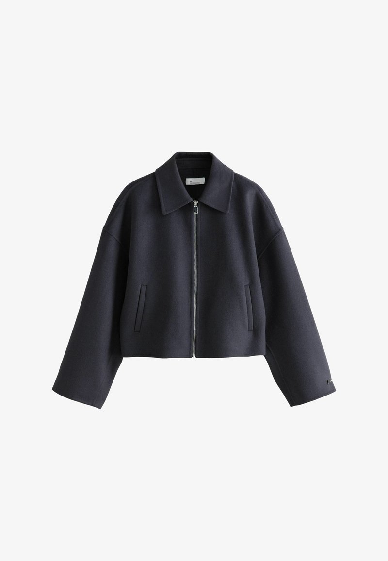 Cropped navy wool jacket with a zip front, pointed collar, and oversized sleeves, featuring two side pockets and a clean, structured design.