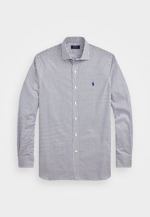 Chemise à boutonner avec un motif à carreaux bleu marine et blanc, manches longues, col et un petit logo brodé sur la poitrine.