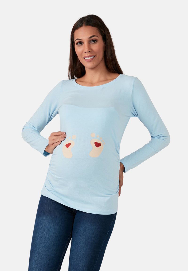 Hellblaues Langarmshirt mit rundem Ausschnitt, das auf der Vorderseite bedruckte Babyfüße und Herzen zeigt. Weicher, dehnbarer Stoff und figurbetontes Design.