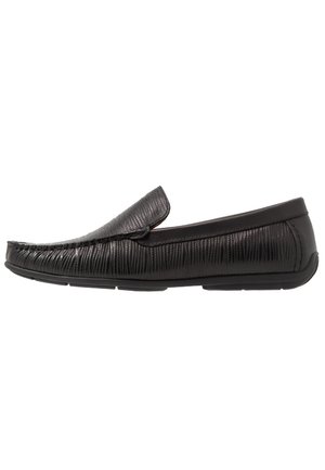 Czarny skórzany mokasyn typu slip-on z teksturowanym wzorem i gumową podeszwą, widoczny z boku.
