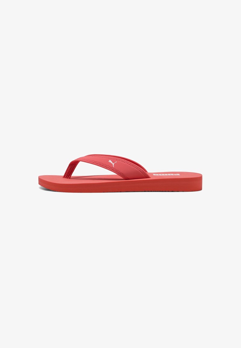 Infradito rossi con una tracolla testurizzata, suola piatta e accento con logo. Realizzate in materiale sintetico, presentano un design minimalista.