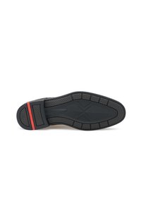 Semelle de chaussure en caoutchouc noir avec une bande de roulement texturée et une bande d'accent rouge, présentant un design solide et des éléments de coussin pour l'adhérence et le confort.