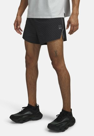 Black athletic shorts with pinstripe pattern and side slits, worn with black shoes featuring white stripes and cushioned soles.