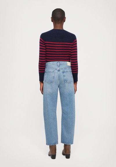 Navy and red striped sweater with long sleeves paired with light blue high-waisted jeans. The jeans have a straight fit and no visible distressing.