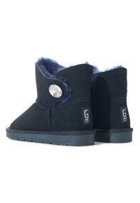 Marineblauwe suède enkellaarzen met faux fur voering, voorzien van een decoratieve knoop en logo-label. Platte rubberen zolen met een gestructureerd loopvlak.